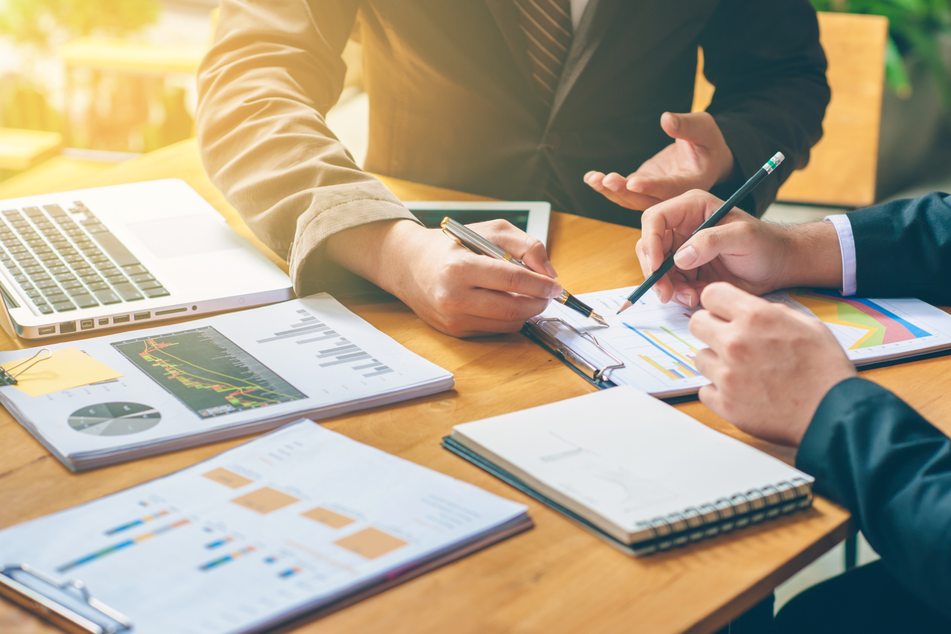 Couple reviewing documents with a financial advisor in a home setting, smiling.