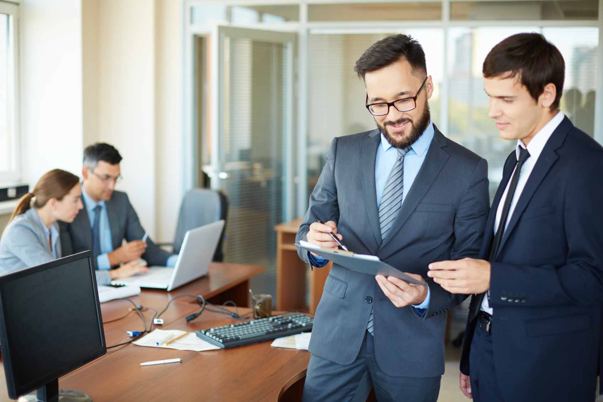 Real estate agent handing keys to a smiling couple after signing a contract.