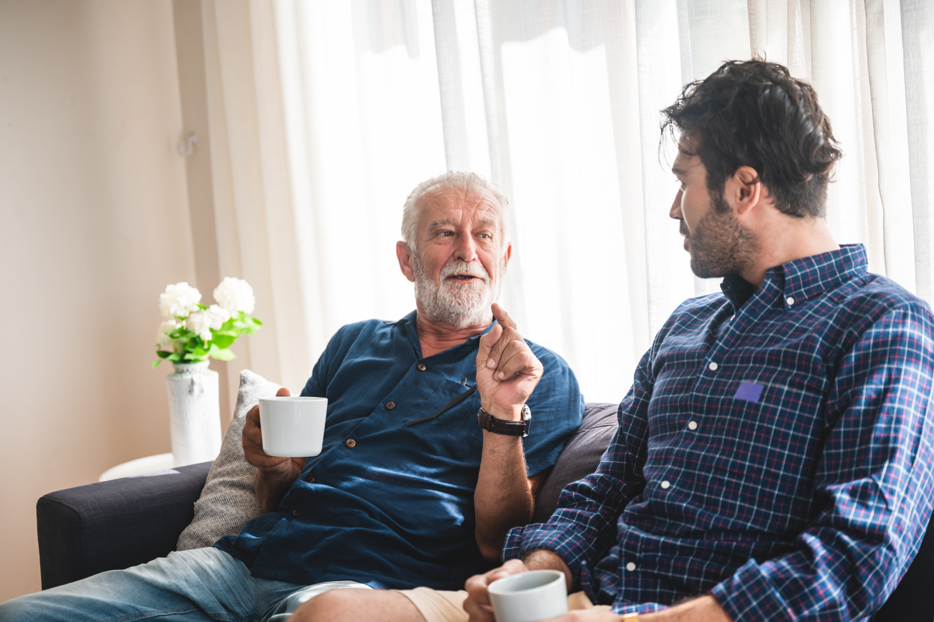 Couple reviewing documents with a financial advisor in a home setting, smiling.