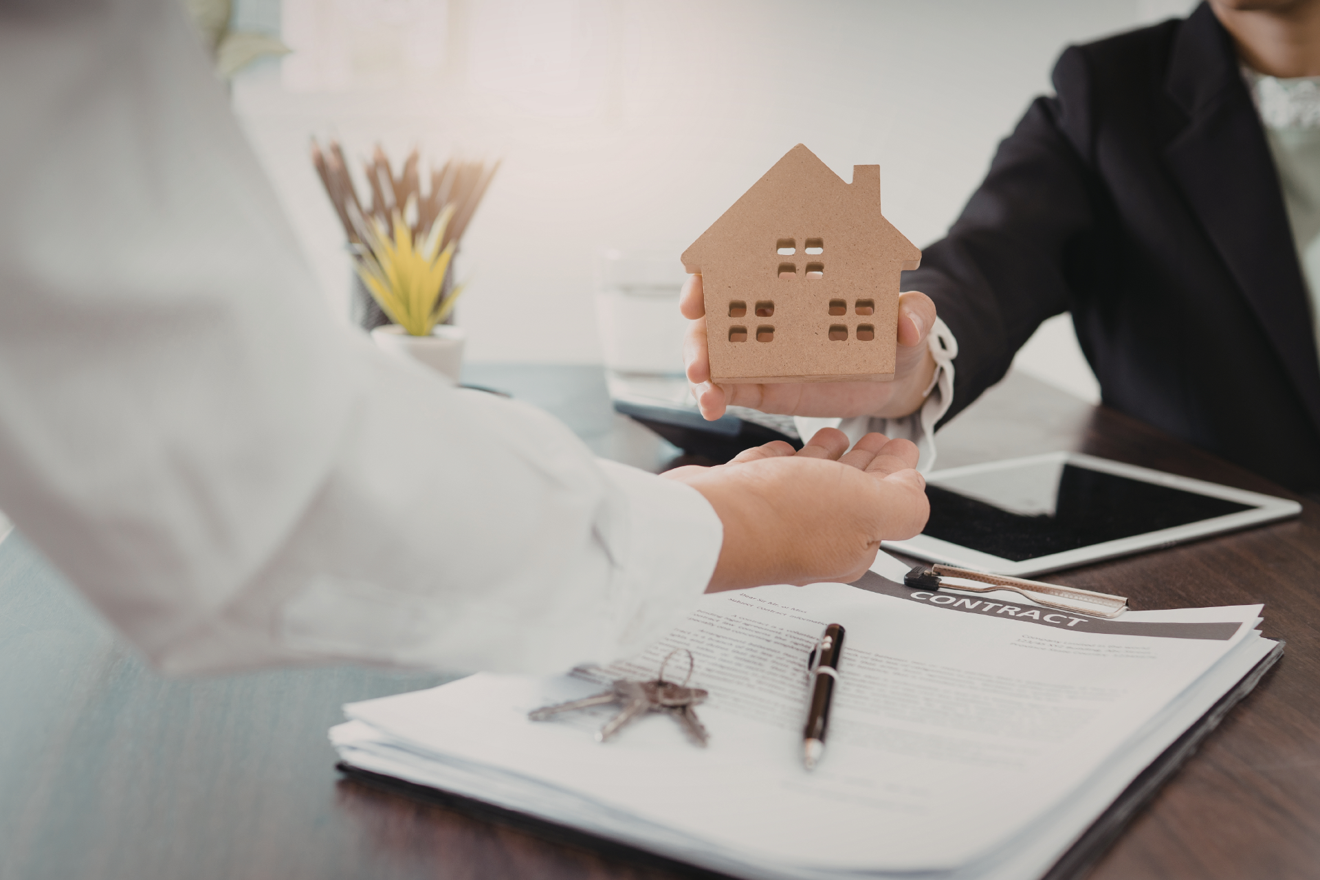 Couple reviewing documents with a financial advisor in a home setting, smiling.