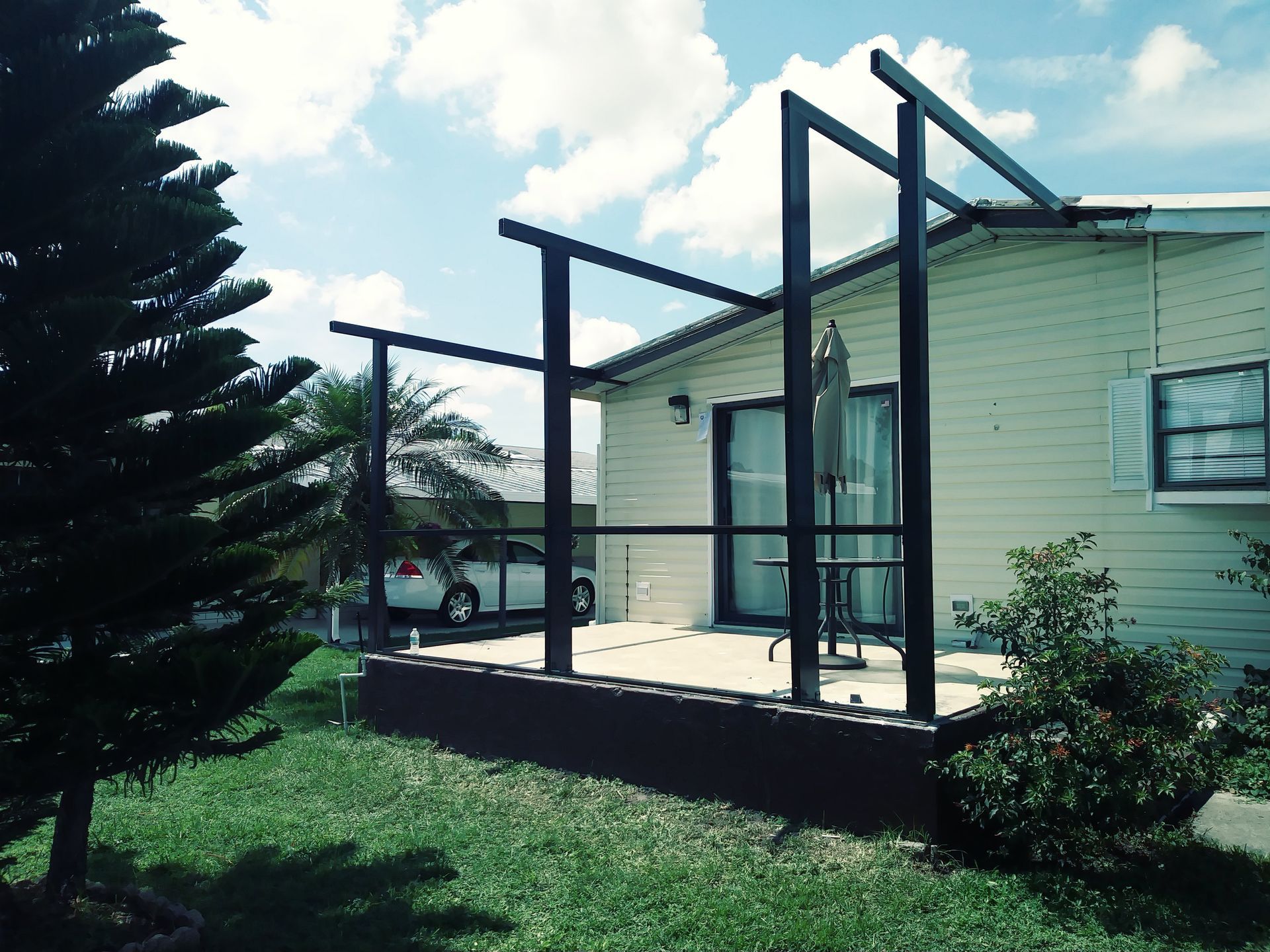 A house with a deck and a car parked in front of it