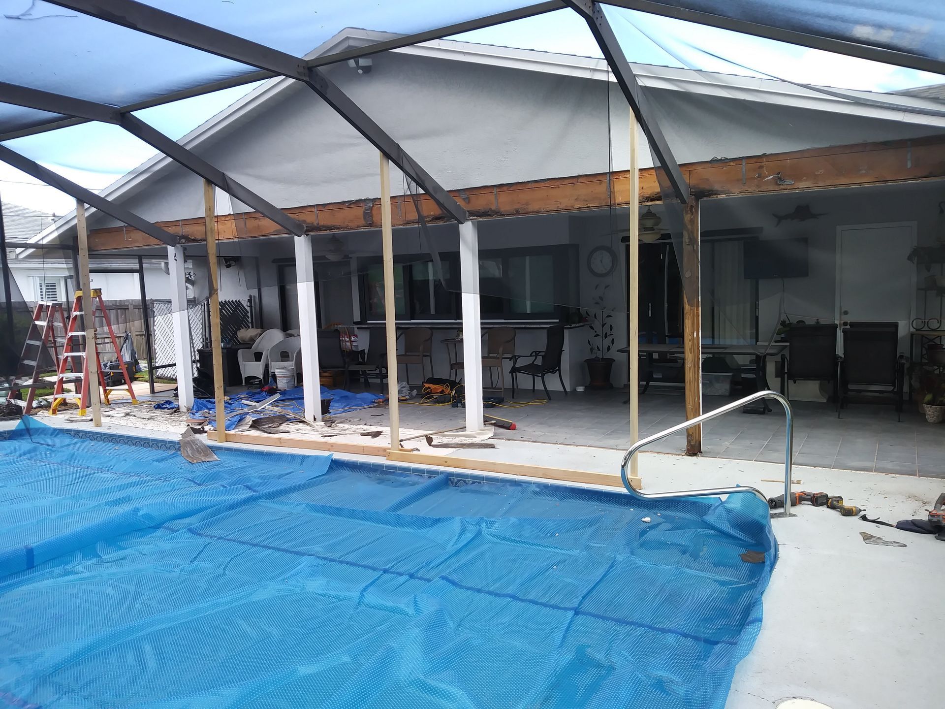 A swimming pool under construction with a blue tarp on it