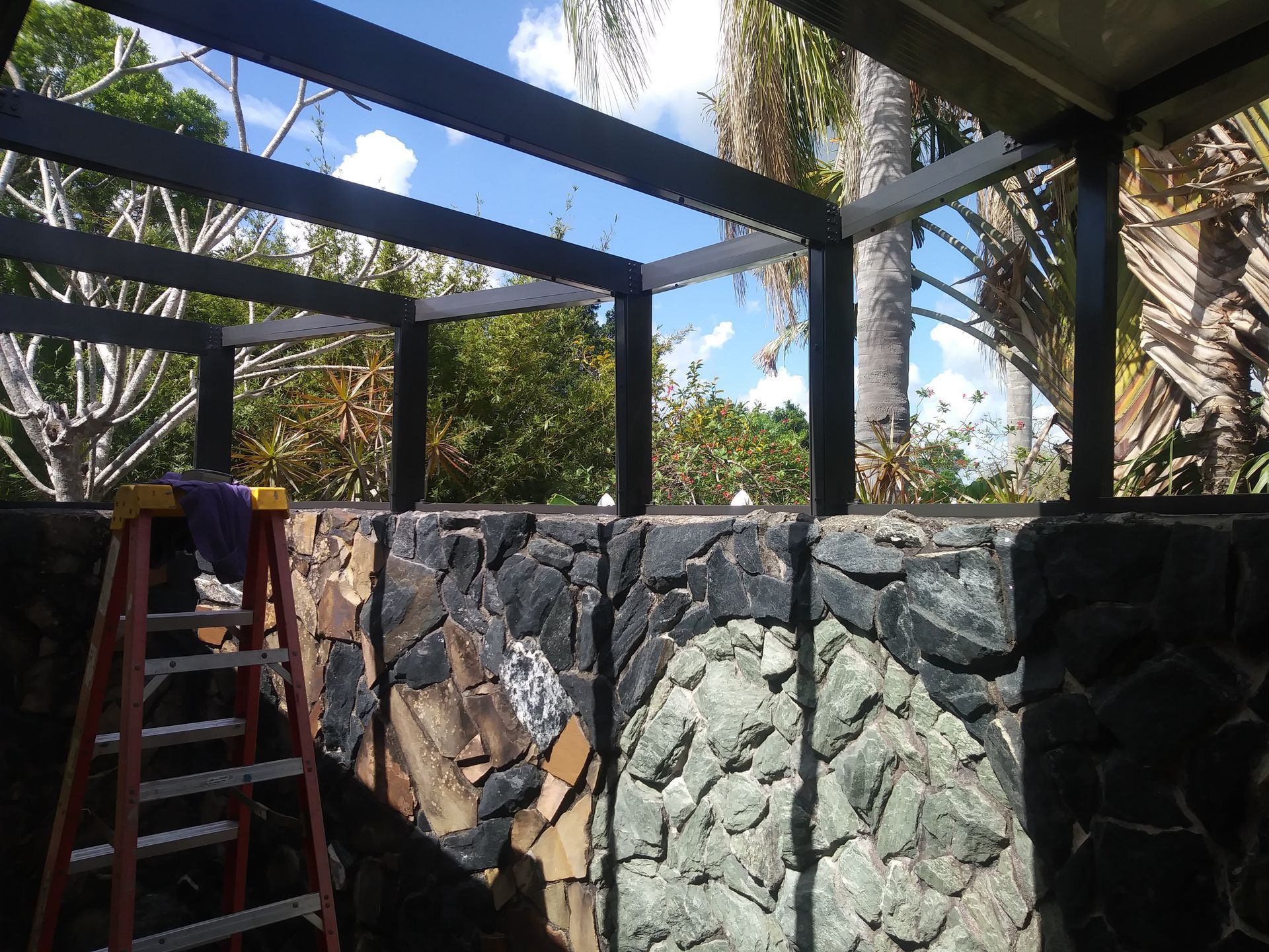 A ladder is sitting in front of a stone wall
