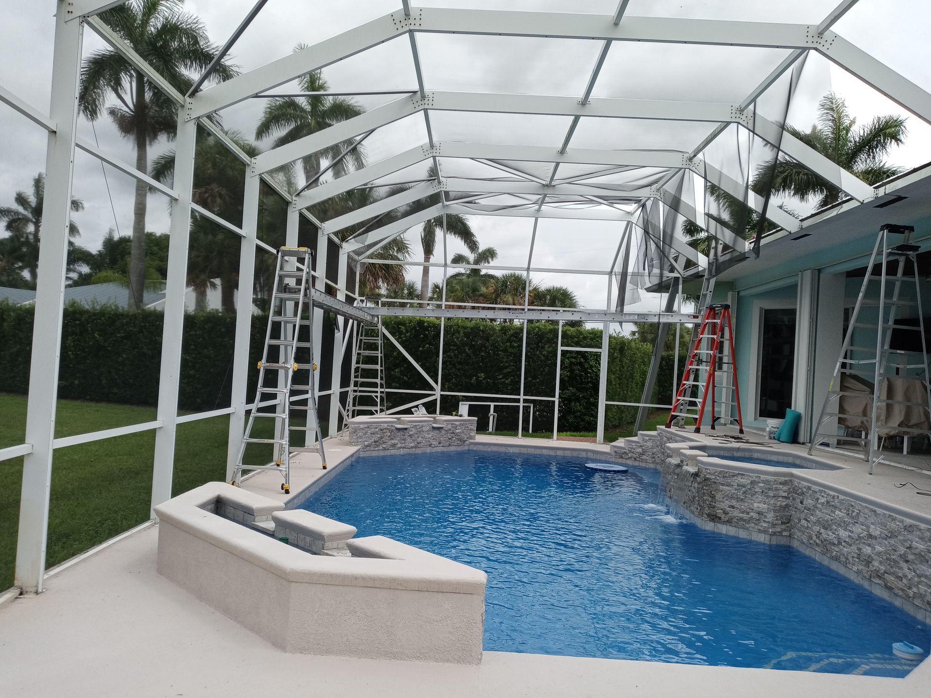 A swimming pool with a screened in area in front of it