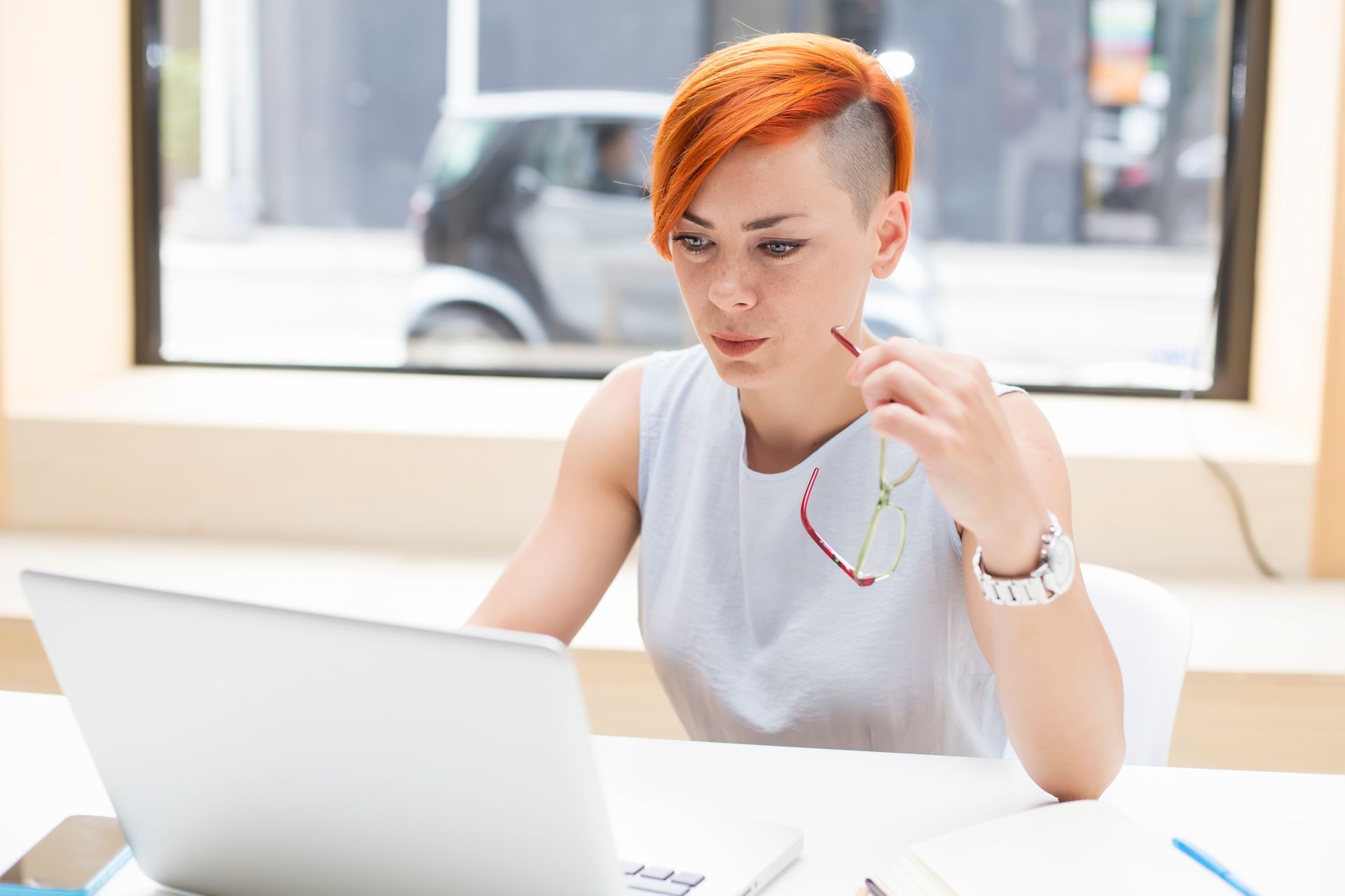 Young redhair woman working on a laptop