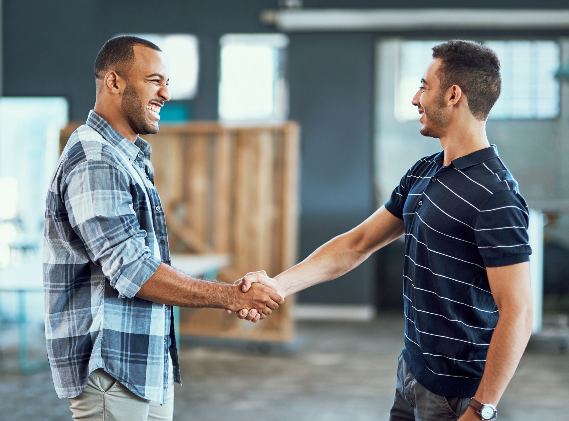 Two men shaking hands and smiling.