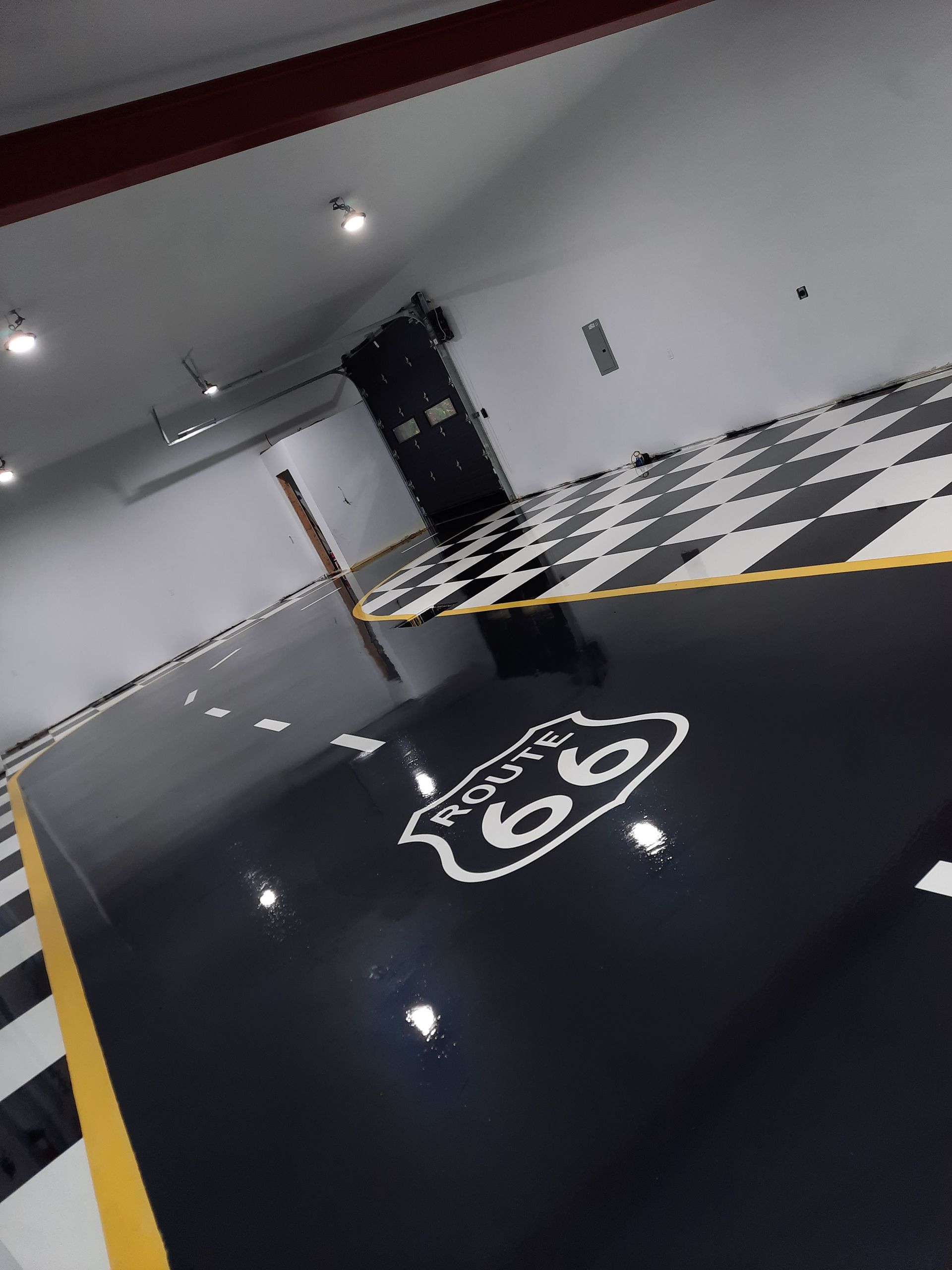 Garage floor with Route 66 sign and checkerboard pattern. Black, white, and yellow design.