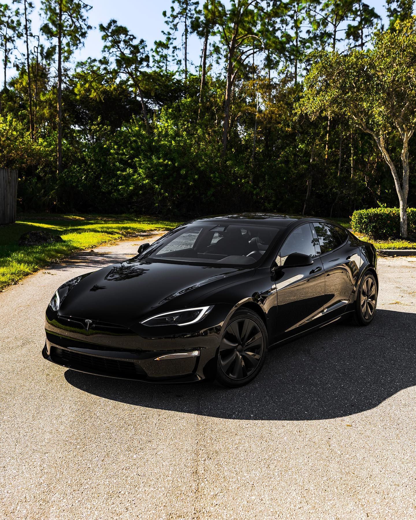 White Porsche 911 GT3 RS with blue accents, parked inside a garage, with logo on wall.