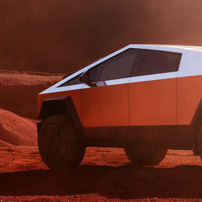 A tesla cybertruck is parked on a dirt road