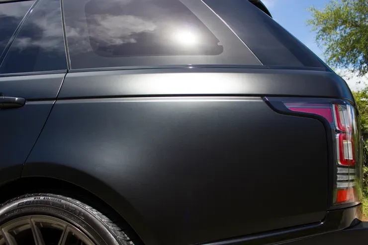 The back of a black range rover is wrapped in matte black vinyl.