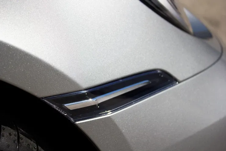A close up of a car 's fender with a light on it.