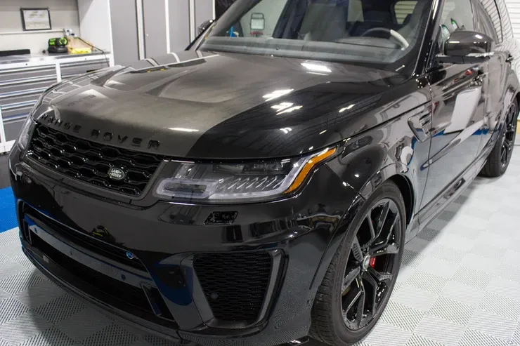 A black range rover sport is parked in a garage.
