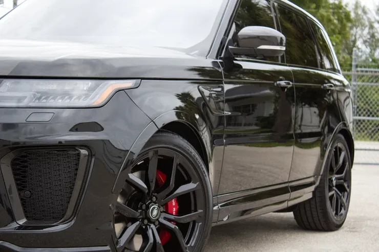 A black range rover sport is parked in a parking lot.