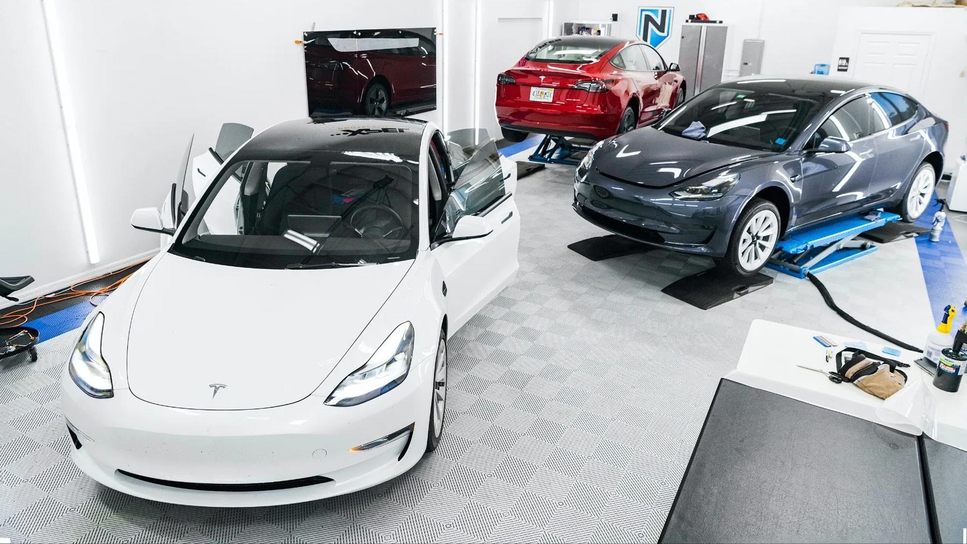 Blue Ferrari sports car, parked on a ramp, silver wheels, and the Ferrari emblem is visible.