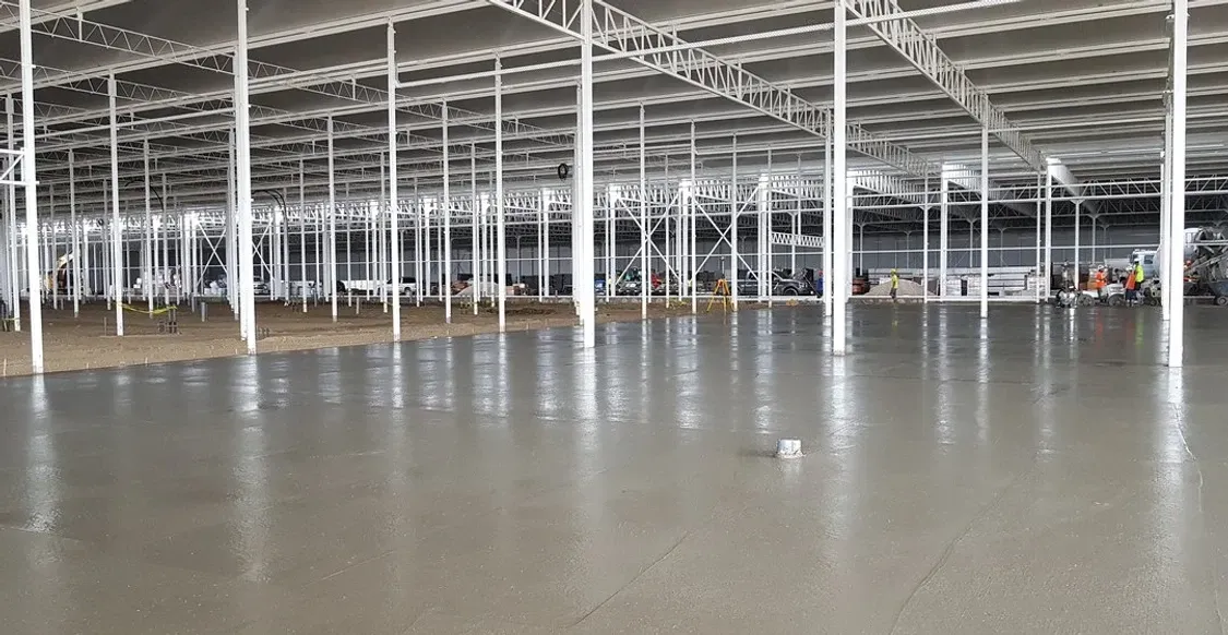 A large empty warehouse with a concrete floor and white columns.