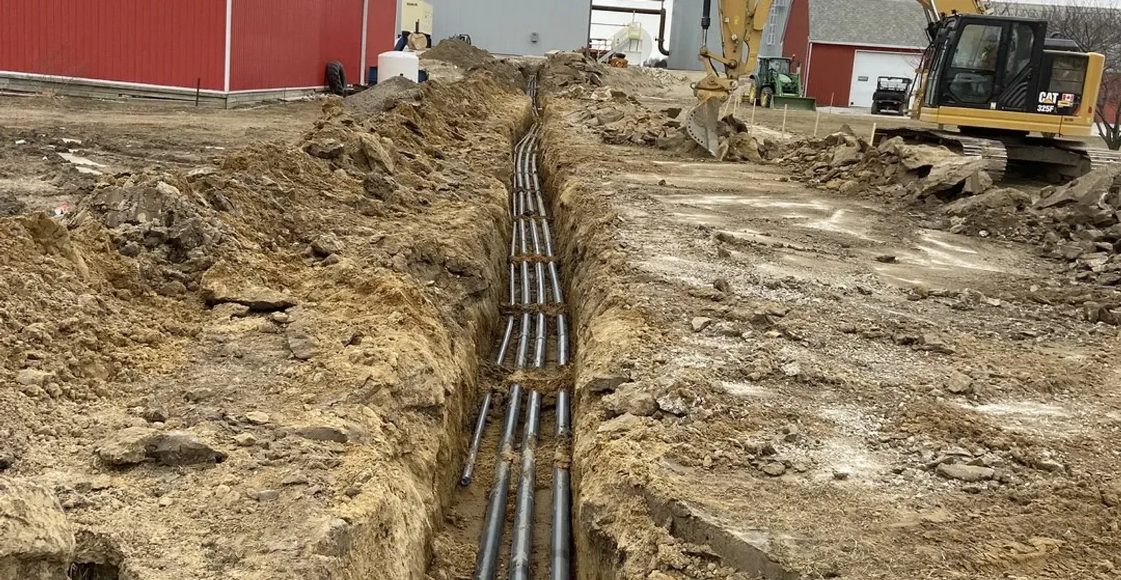 A construction site with a lot of dirt and pipes in the ground.
