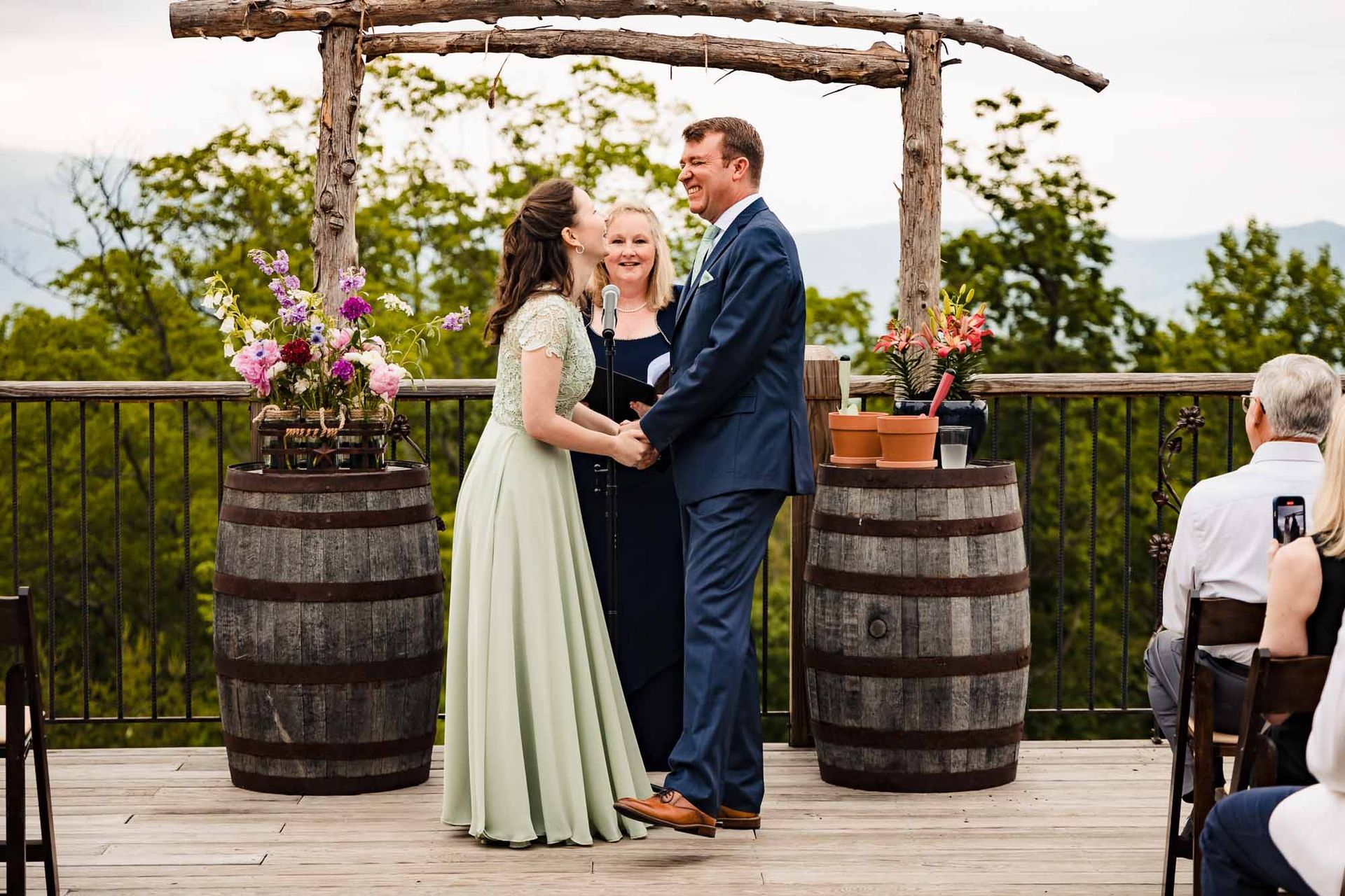 A bride and groom are holding hands during their wedding ceremony.