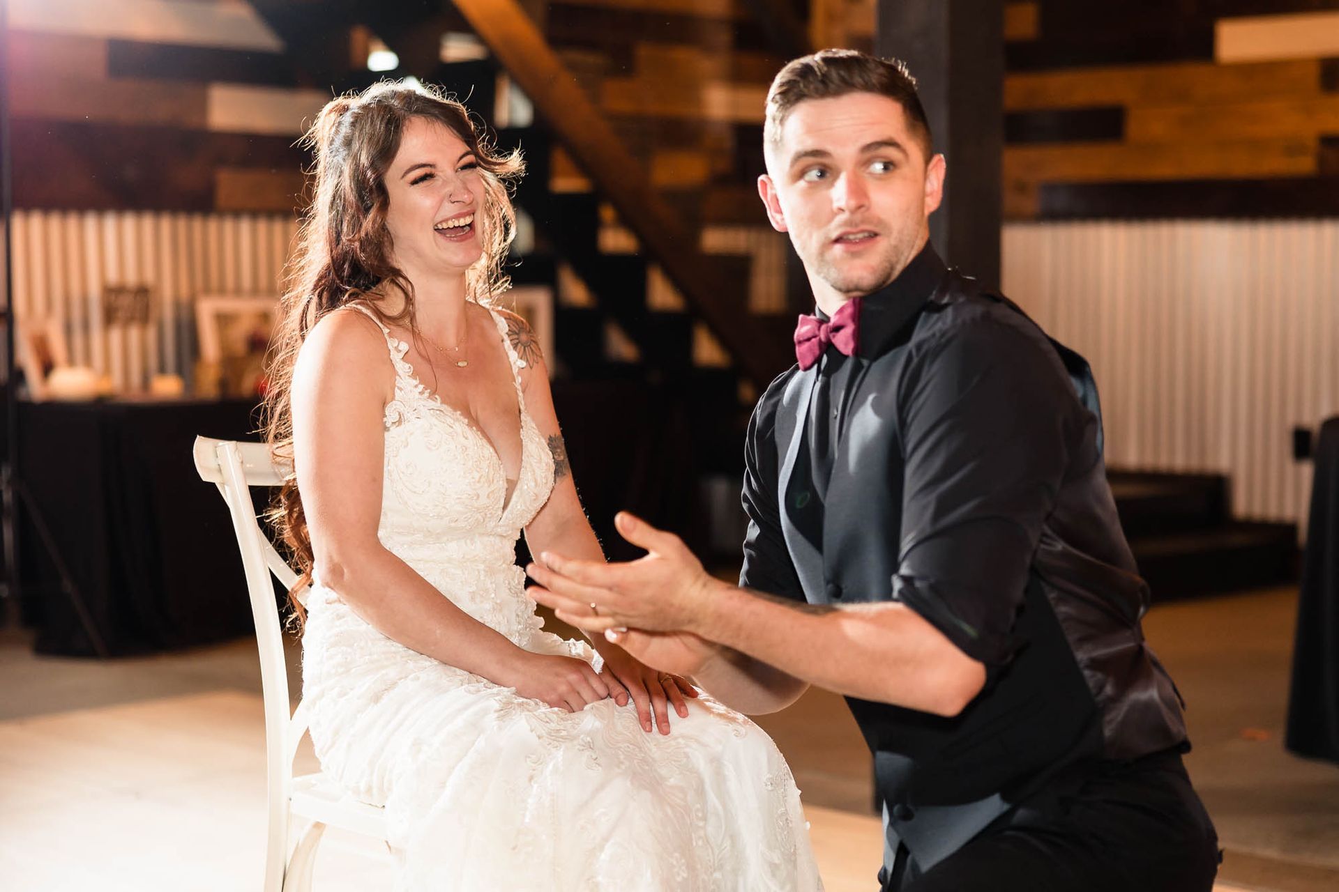A bride and groom are sitting in chairs at a wedding reception.