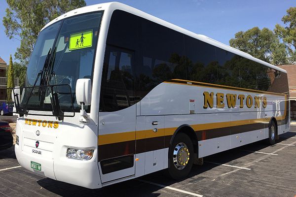 A newtons bus is parked in a parking lot