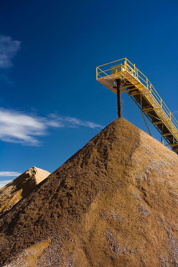 A conveyor belt is sitting on top of a pile of dirt.