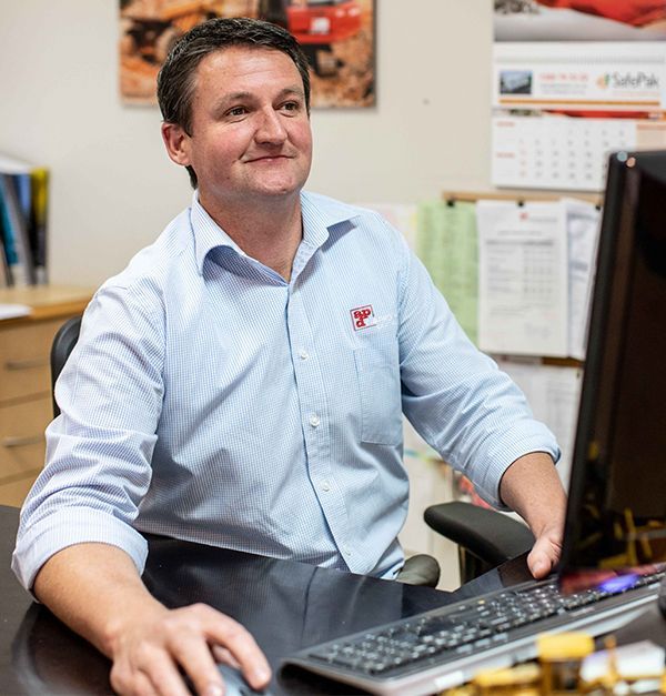 A man is sitting at a desk using a computer
