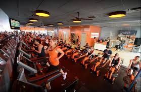 A group of people are riding exercise bikes in a gym.