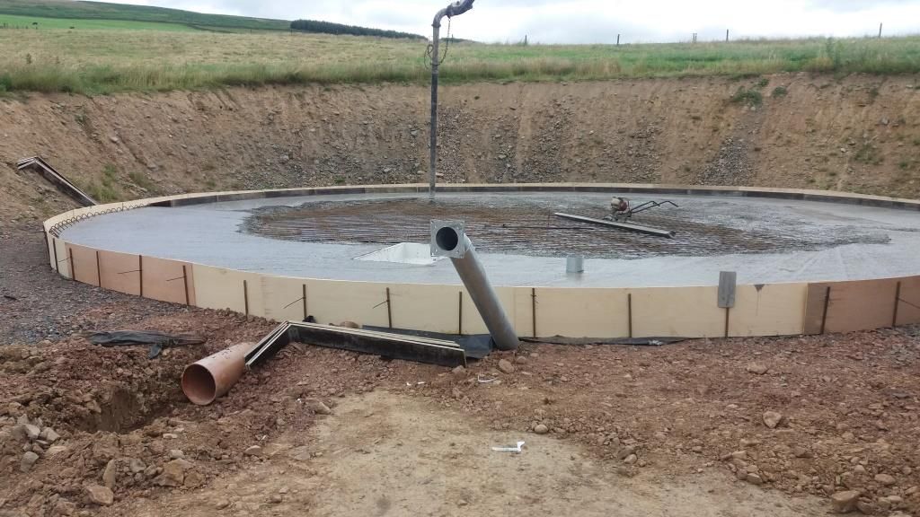 Workers leveling concrete with mix trowel on a construction site for a concrete driveway.