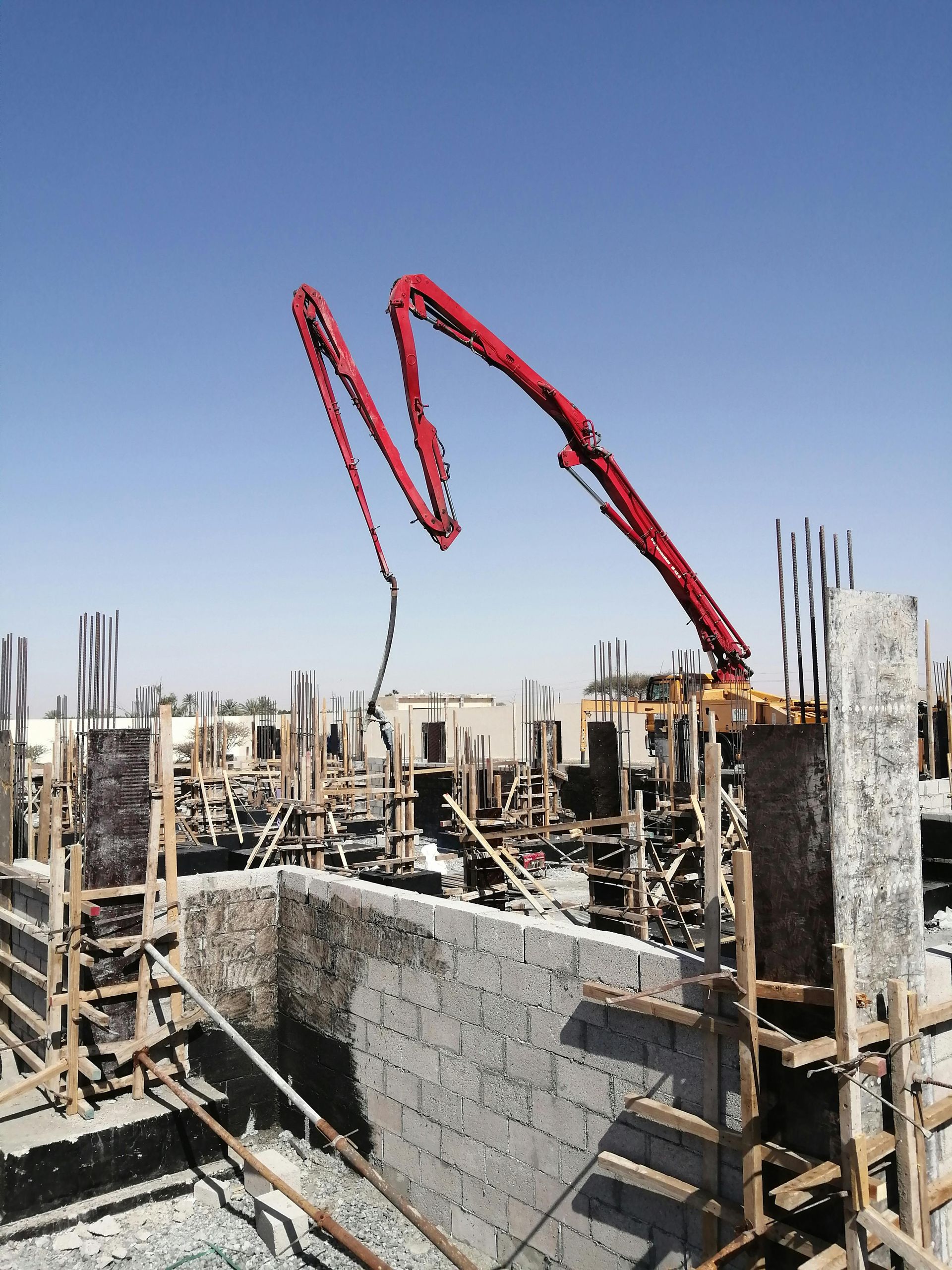 Workers leveling concrete with mix trowel on a construction site for a concrete driveway.