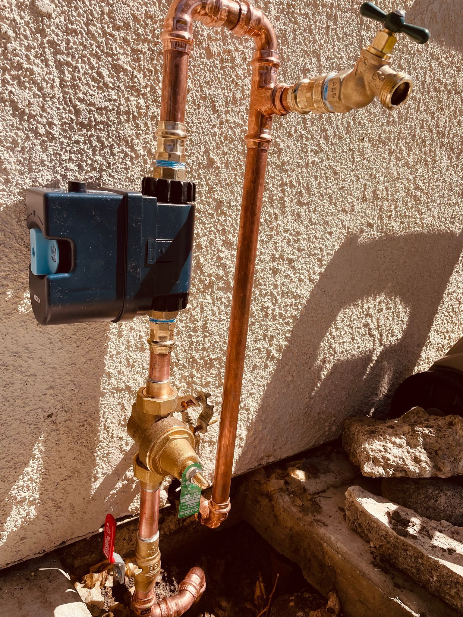 A plumber is fixing a sink pipe with a wrench.