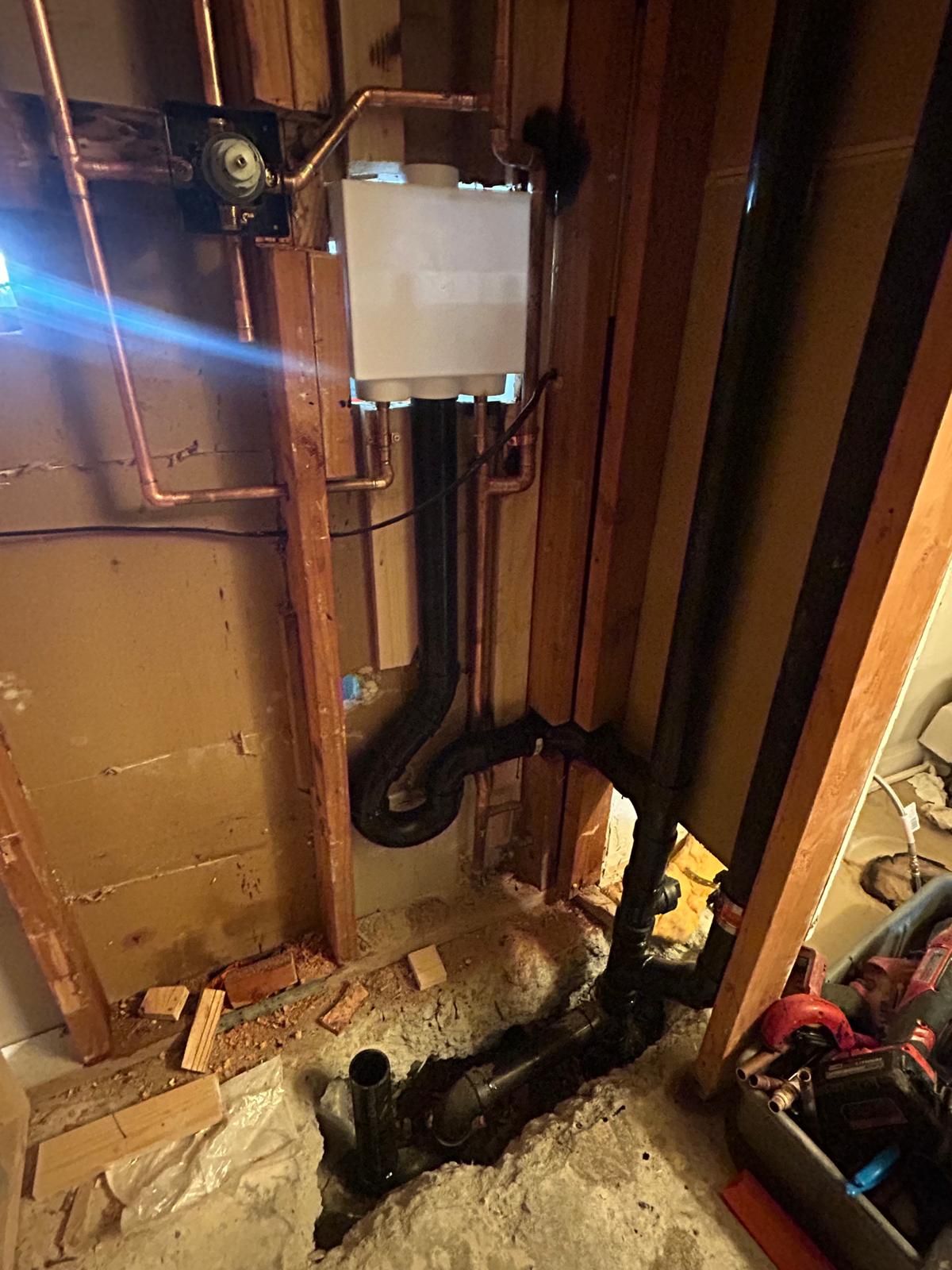 A man is fixing a boiler with a screwdriver.