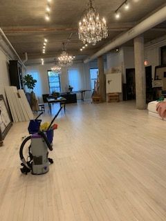 A vacuum cleaner is sitting on the floor of a large room.