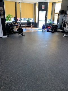 A large room with a lot of exercise equipment in it.