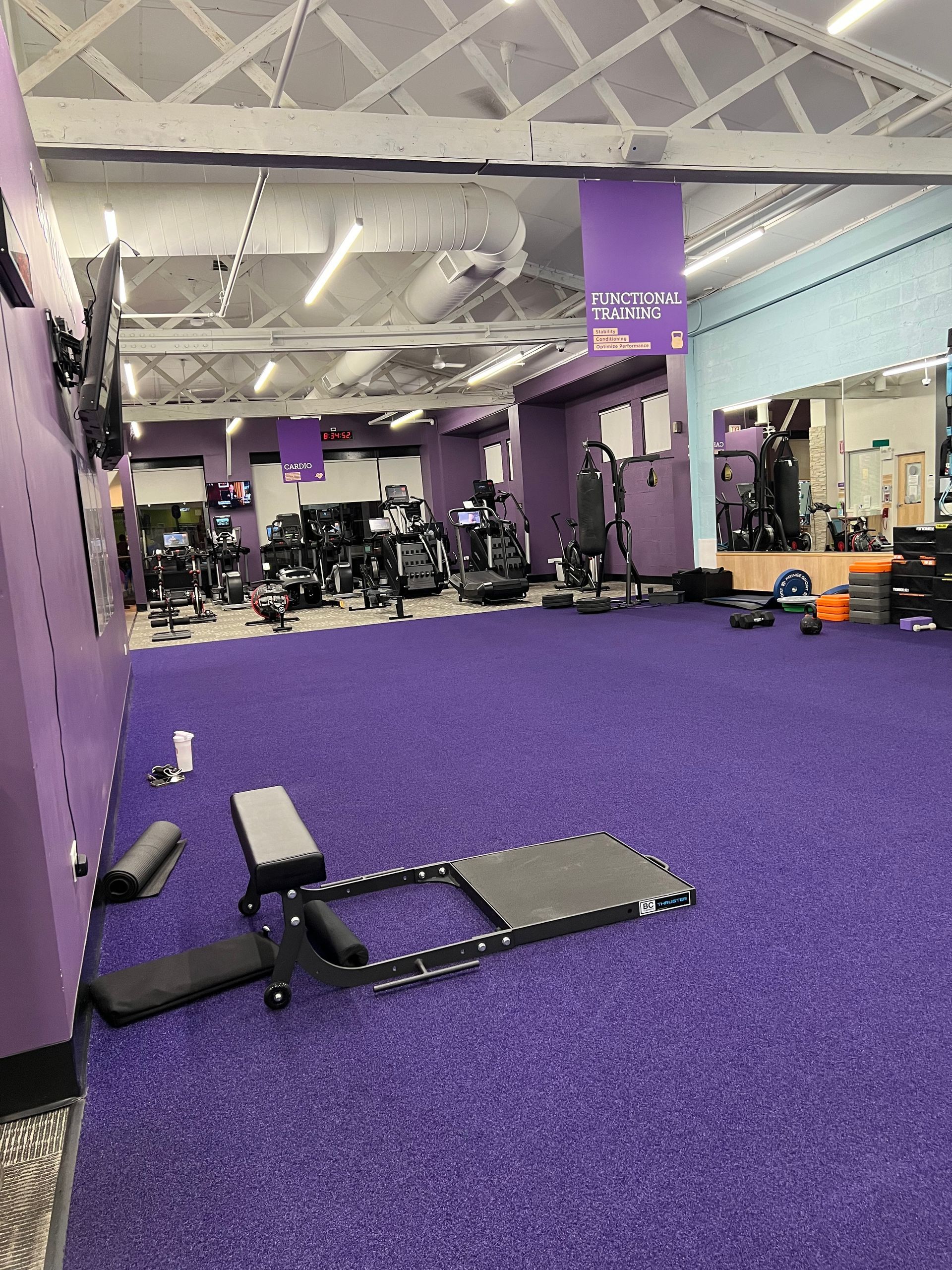A gym with a purple carpet and lots of exercise equipment.