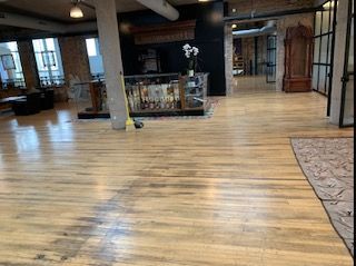 A large room with a wooden floor and a rug.