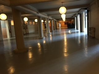 A long hallway with columns and lights hanging from the ceiling.