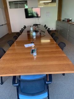 A conference room with a long wooden table and chairs.