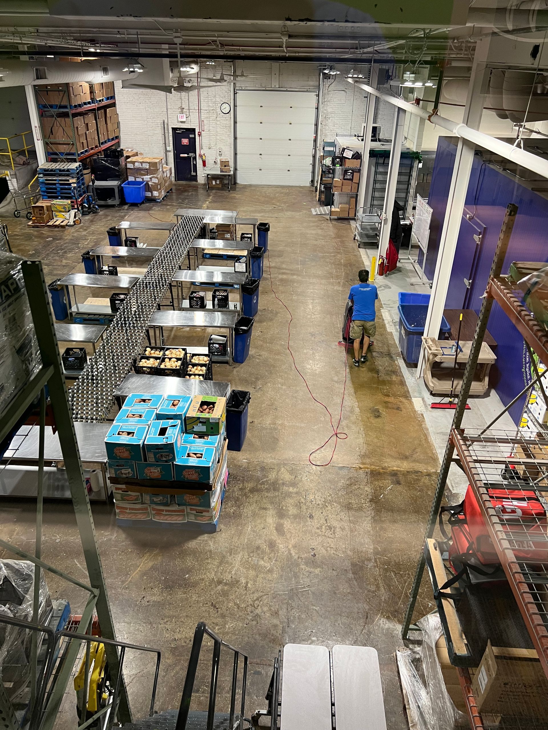 An aerial view of a large warehouse filled with lots of boxes and tables.