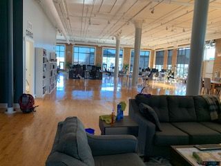 A living room with a couch and chairs in a large room.
