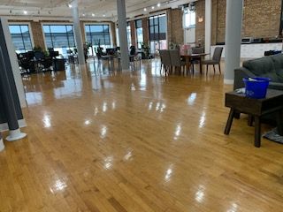 A large room with wooden floors and tables and chairs.