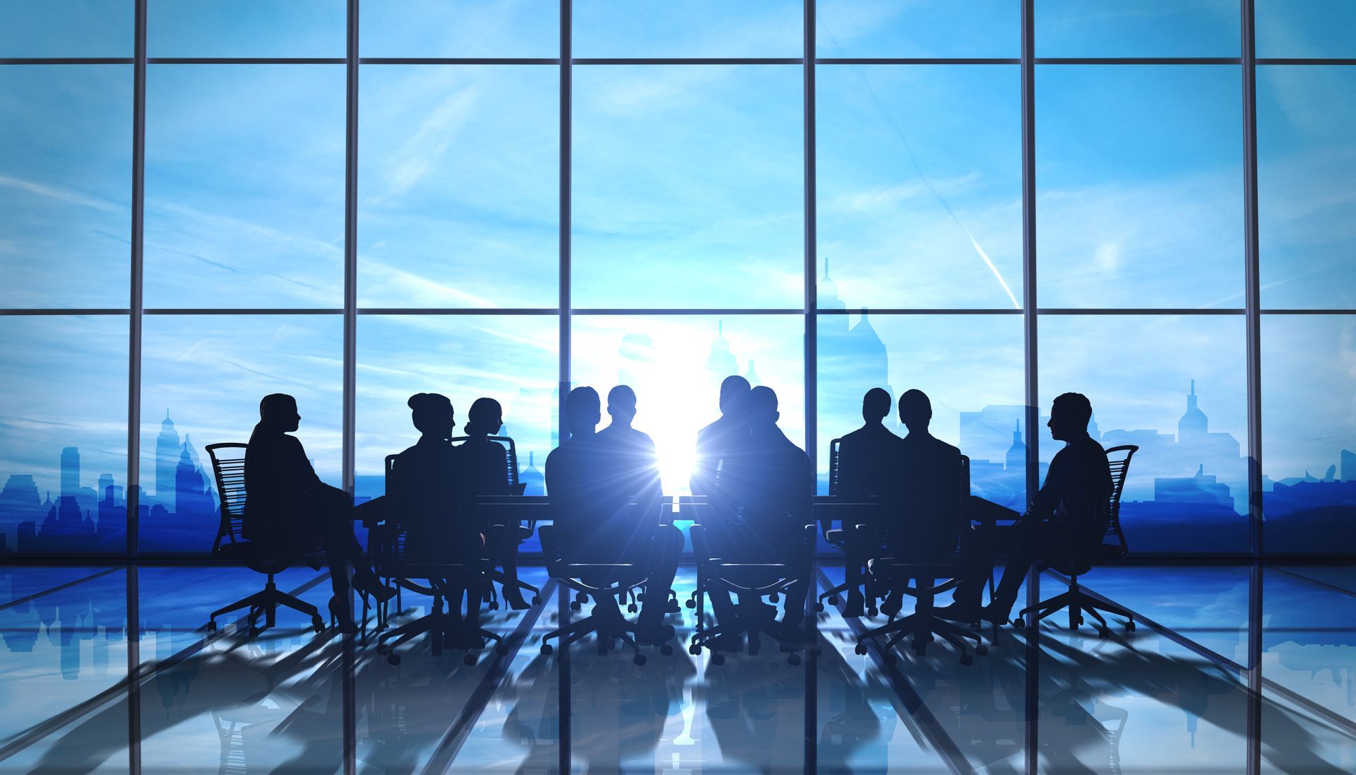 Silhouetted figures in a conference room with large windows, city skyline visible, sun shining.