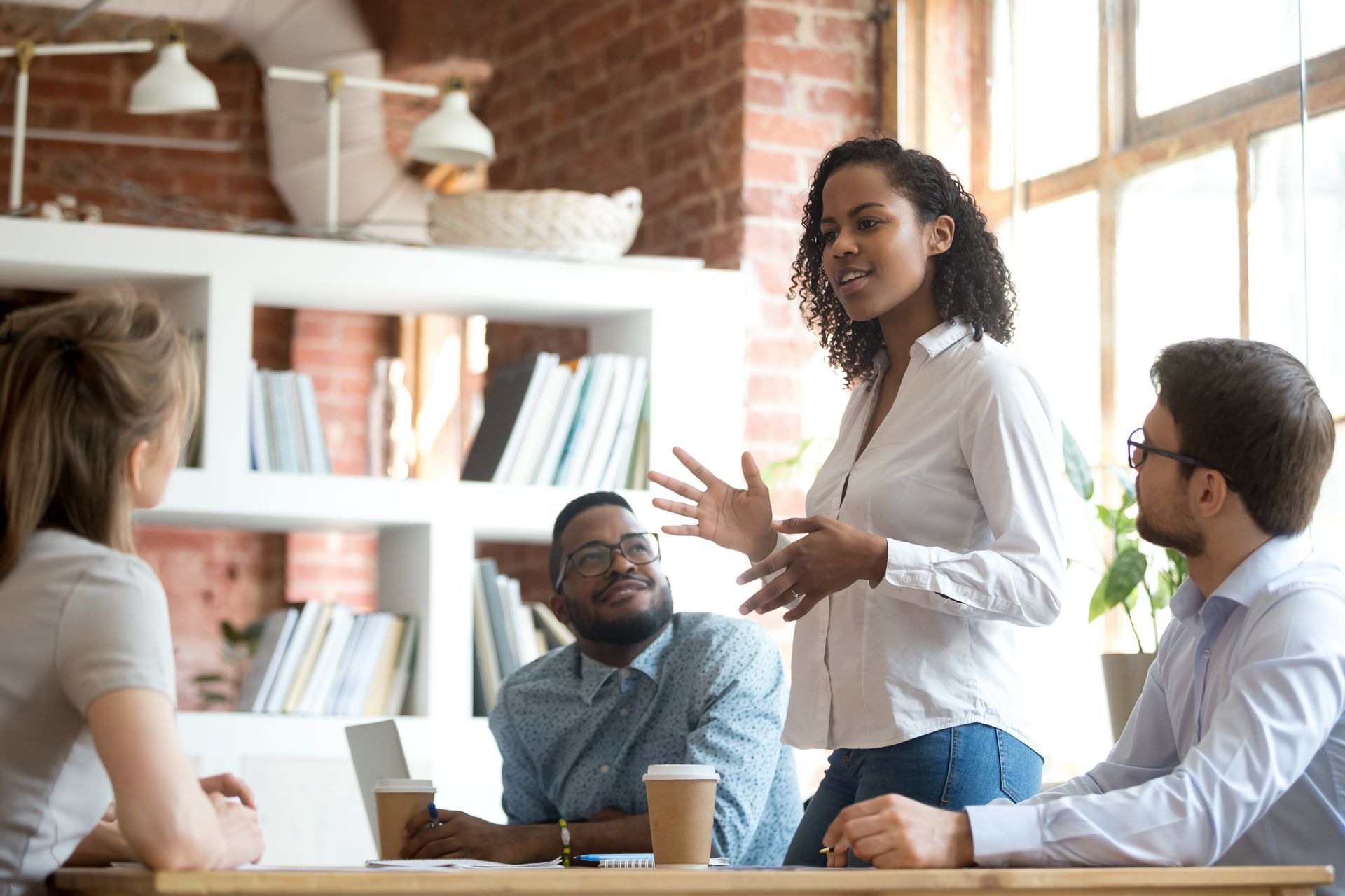 Woman speaking to colleagues in an office setting; discussing a project.