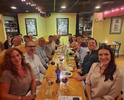 Business meeting: Man in suit speaks to group seated around a table. Bright, window-lit room. Business meeting: Man in suit speaks to group seated around a table. Bright, window-lit room.