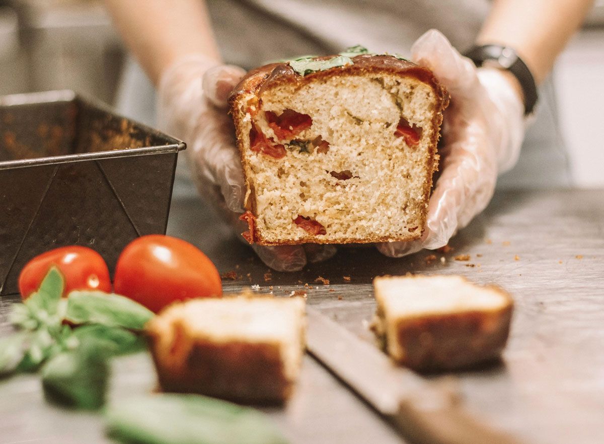 A person is holding a loaf of bread in their hands.