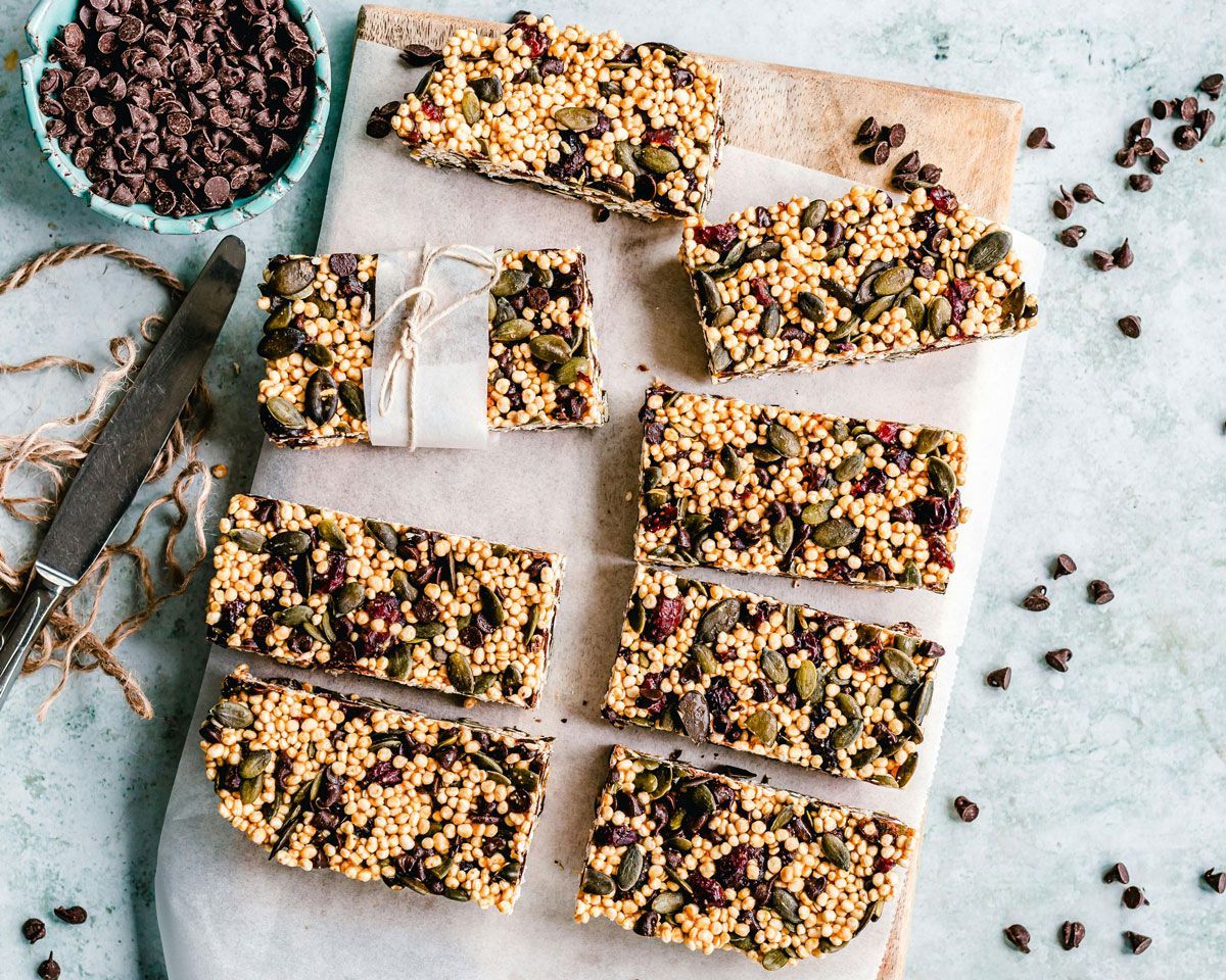A cutting board topped with granola bars and chocolate chips.