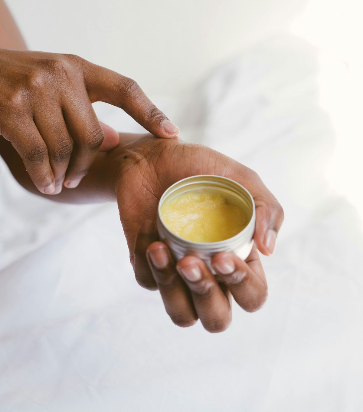 A person is applying a cream to their wrist.