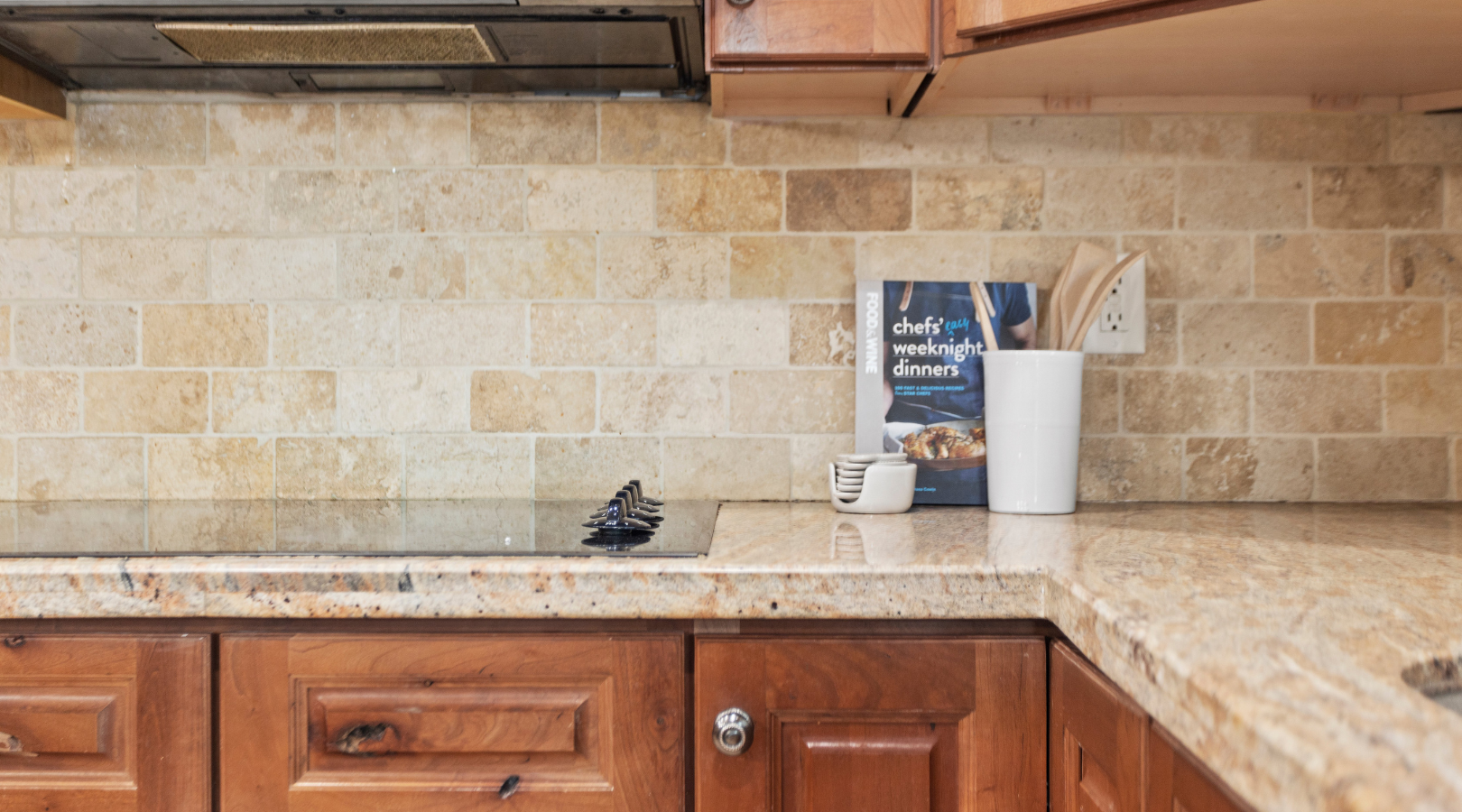 A kitchen with wooden cabinets and granite counter tops.