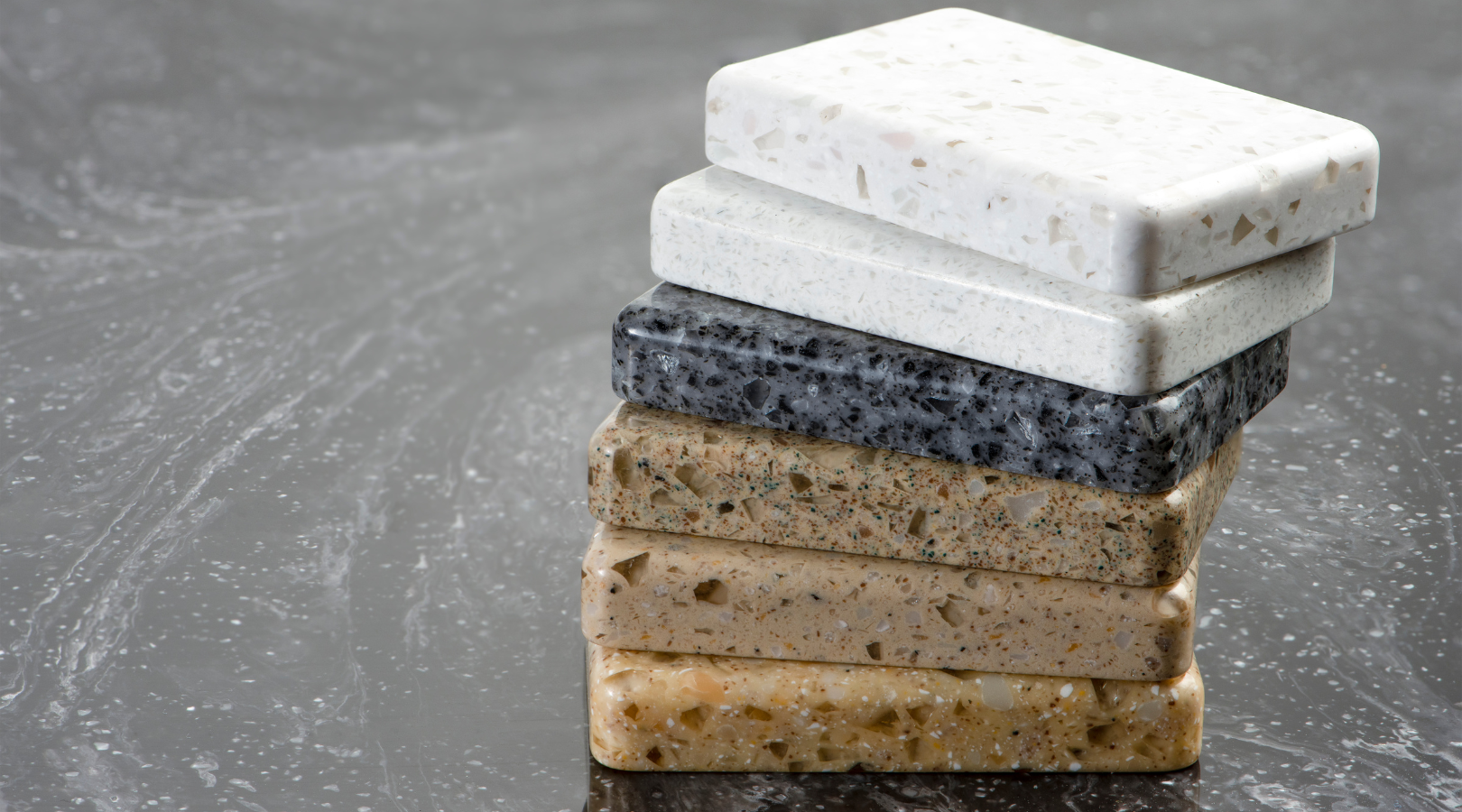 A stack of different types of natural stone slabs on a table.