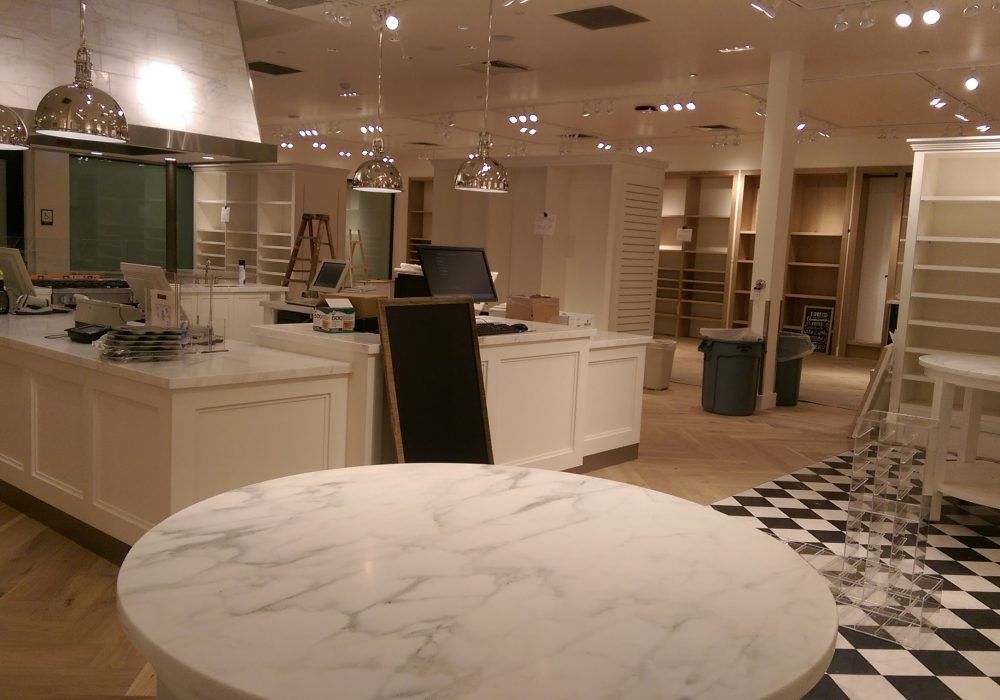 A large room with a checkered floor and a marble table