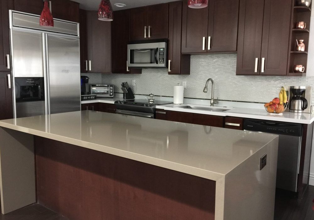 A kitchen with stainless steel appliances and brown cabinets