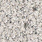 A close up of a white granite counter top with black spots.